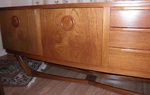 Beautility teak sideboard with a bow front raised on a floating base